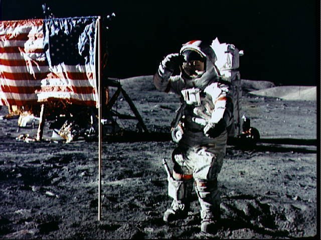 Astronaut Eugene Cernan salutes deployed U.S. flag on lunar surface